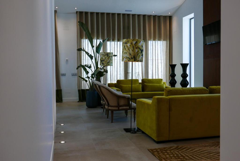 a living room with yellow furniture and a yellow couch at el arrabal de toledo in Cobisa