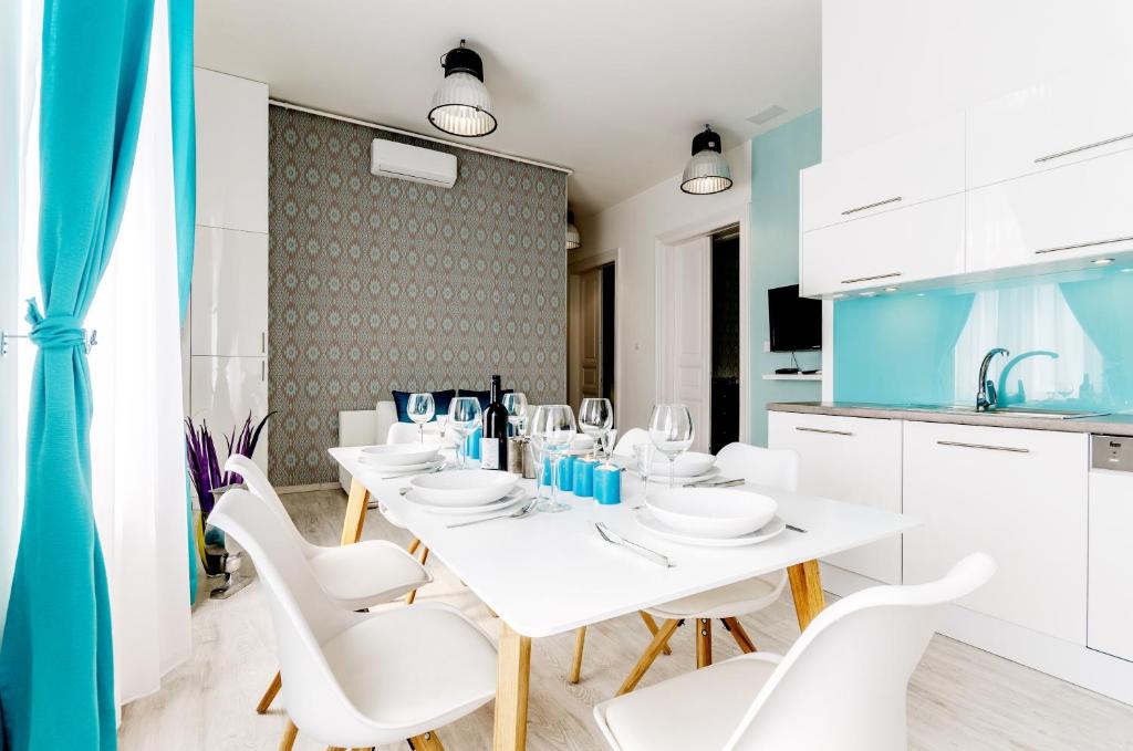 a white dining room with white tables and white chairs at Downtown Residences in Budapest