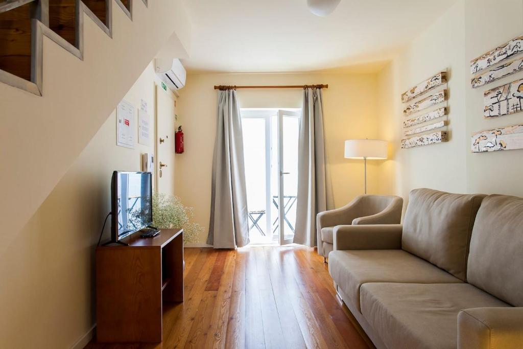 ein Wohnzimmer mit einem Sofa und einem TV in der Unterkunft Exquisit Flat Right in Lissabon
