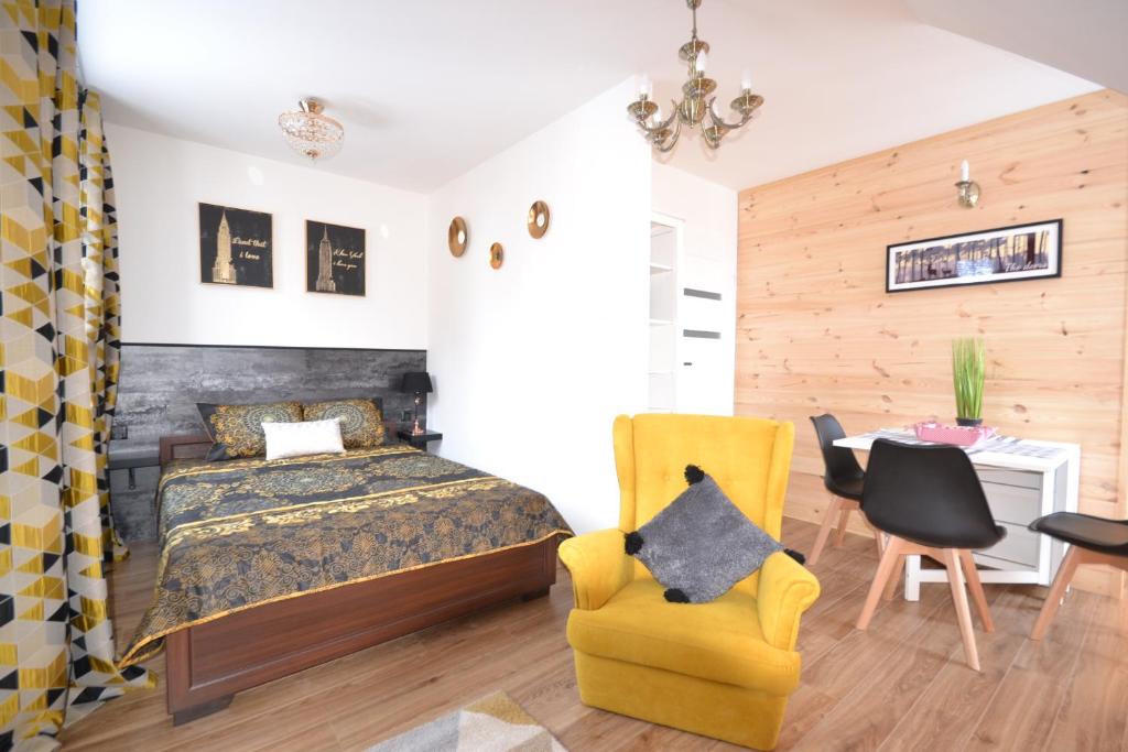 a bedroom with a bed and a yellow chair at Golden Mountain in Karpacz