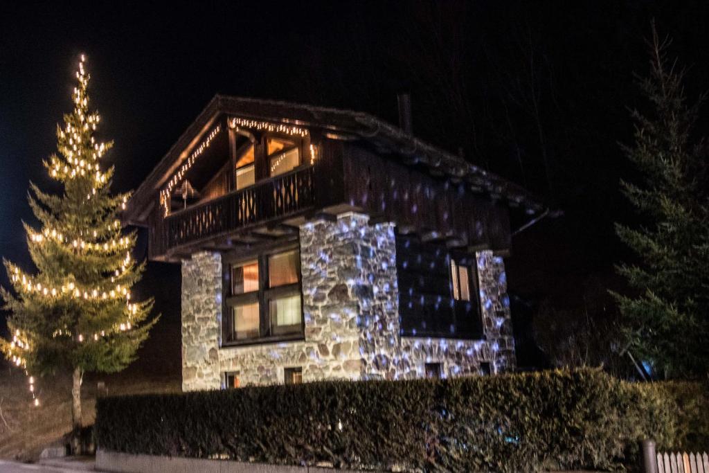 a house with a christmas tree in front of it at Tabiè Dli Cuuntini in Dosoledo
