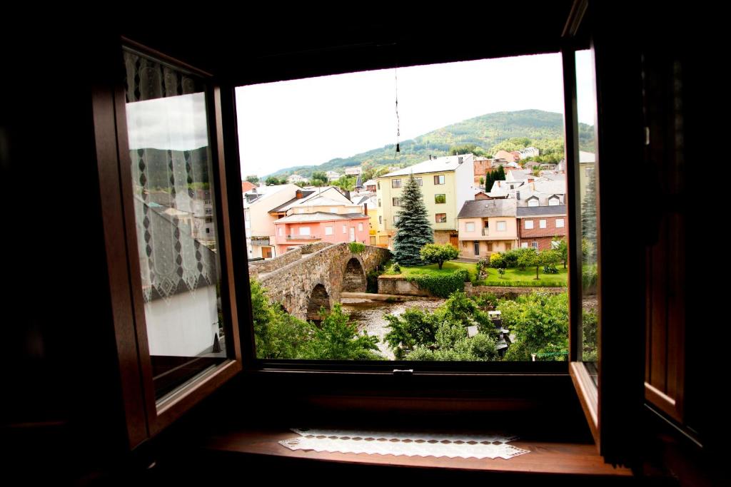 ein offenes Fenster mit Stadtblick in der Unterkunft Dos Puentes in Vega de Espinareda