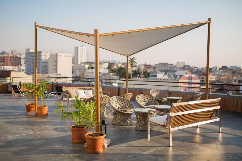 a patio with chairs and tables on a roof at Tsanga Tsanga Hotel in Antananarivo