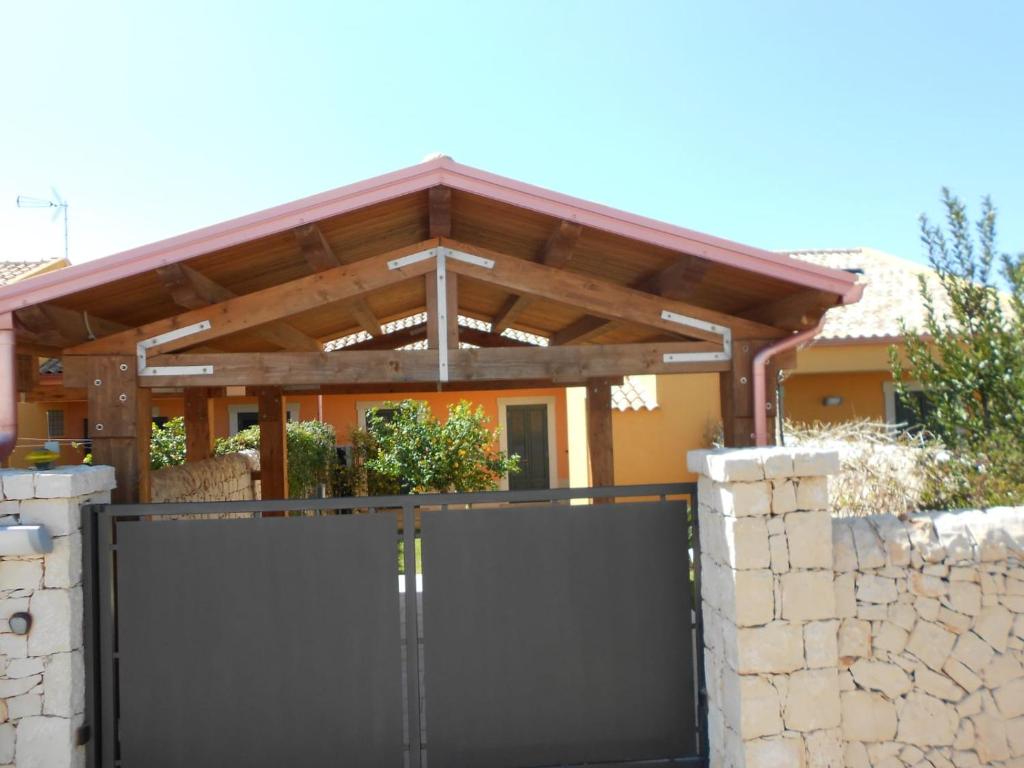 une porte menant à une maison dotée d'une pergola en bois dans l'établissement Villa Relax, à Donnalucata