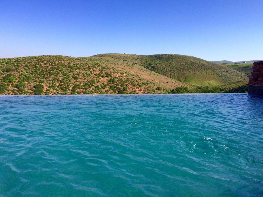 a large body of water with mountains in the background at Hotel De Charme Les 3 Chameaux 4 étoiles in Mirleft