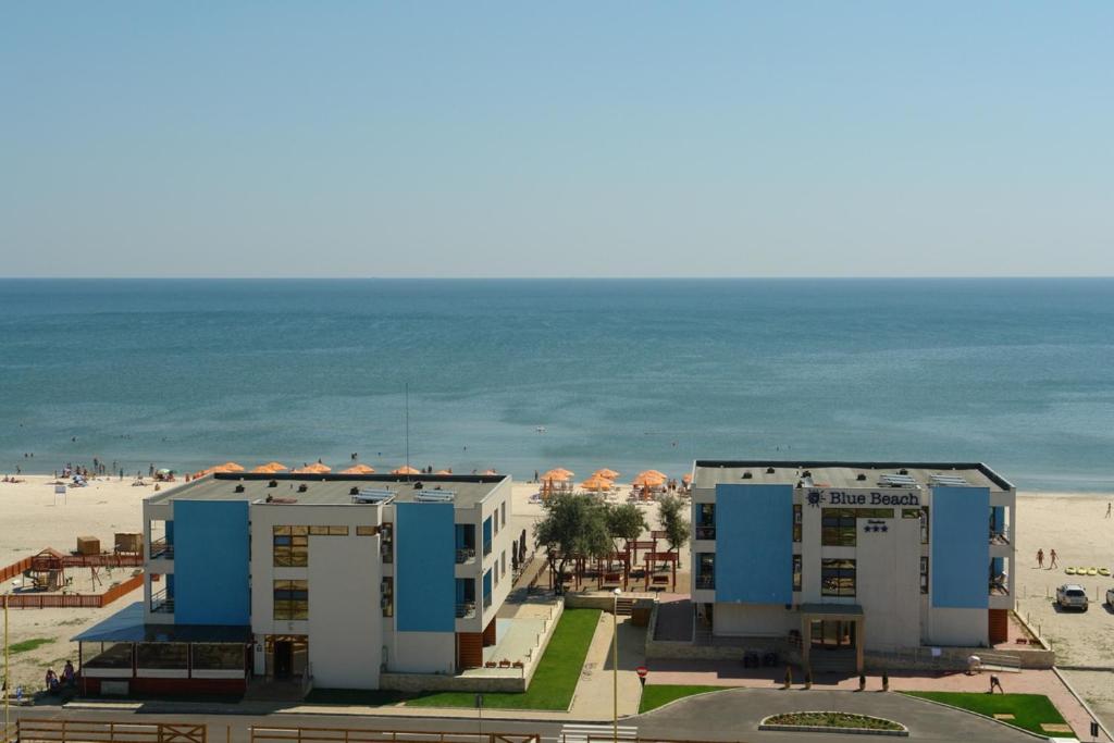 a view of two buildings and the beach at Blue Beach Studios in Mamaia