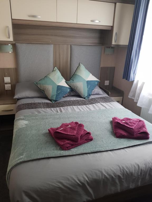 a bedroom with a bed with towels on it at 3 bedroom caravan with hot tub Tattershall lakes in Tattershall