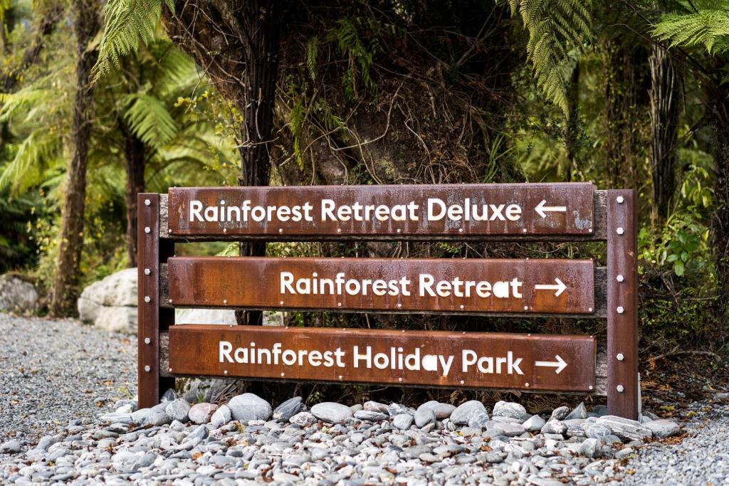 a wooden bench with a sign on it at Rainforest Retreat in Franz Josef