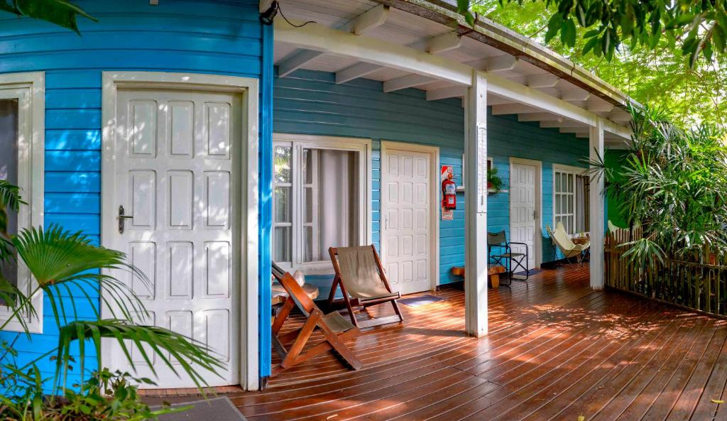 a blue house with a white door and a deck at Secret Garden Iguazu in Puerto Iguazú