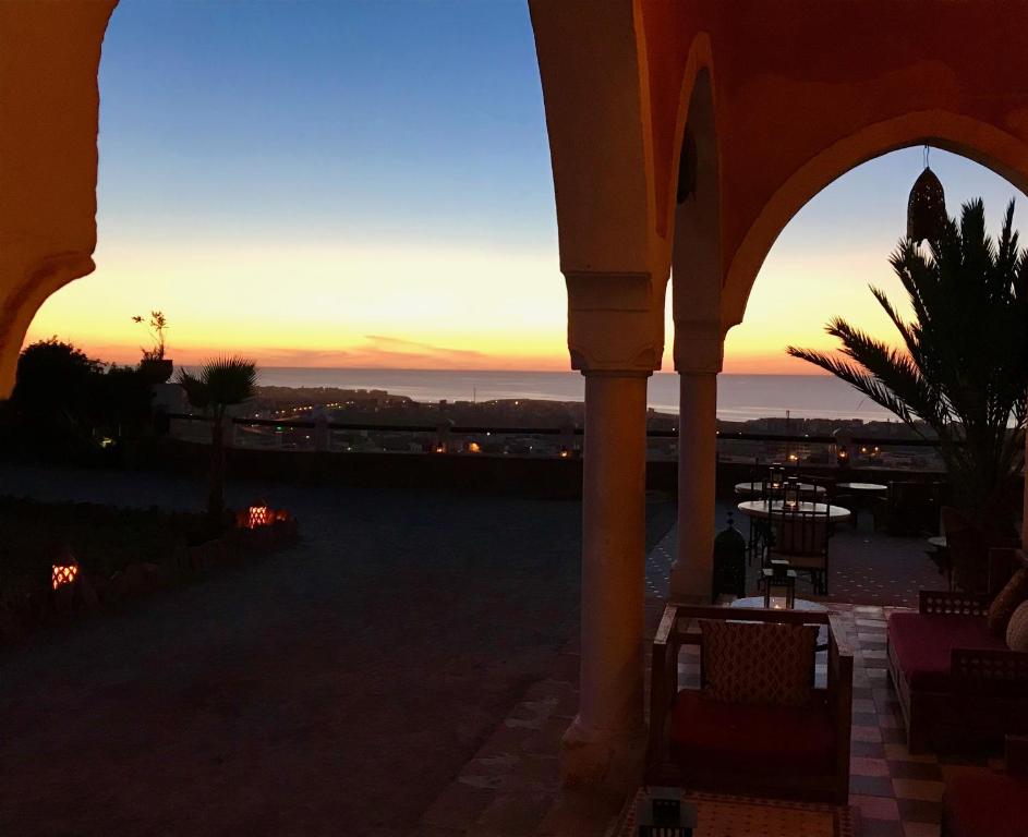 a sunset from the patio of a building at Hotel De Charme Les 3 Chameaux 4 étoiles in Mirleft