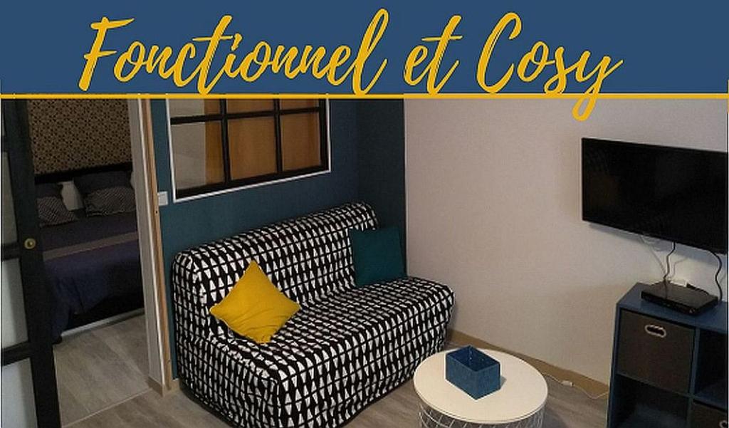 a living room with a black and white couch with a yellow pillow at Joli petit logement en centre ville de Brioude in Brioude