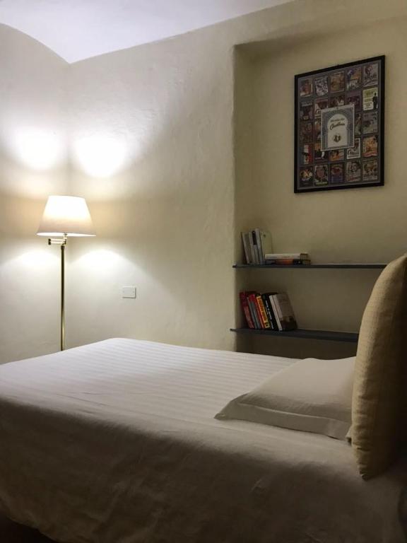 a bedroom with a bed with a lamp and a picture on the wall at BBQ Lodge in Camogli