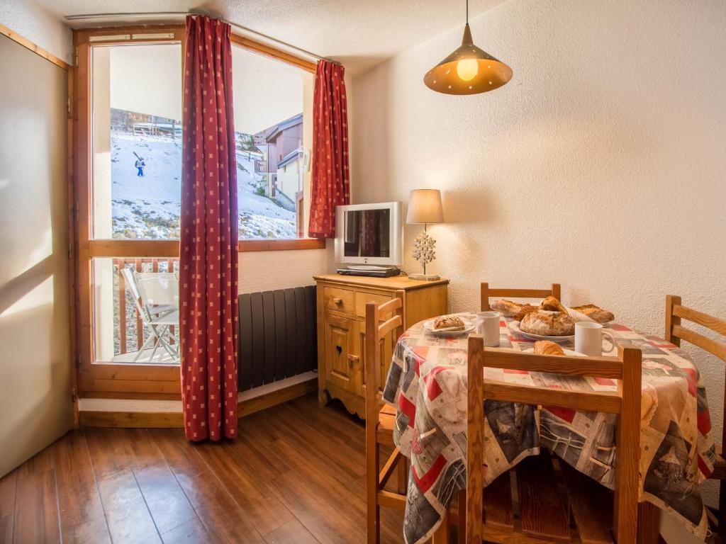 26 Praz de l'Ours Vallandry - Paradiski في بيسي-نانكرويكس: غرفة طعام مع طاولة ونافذة