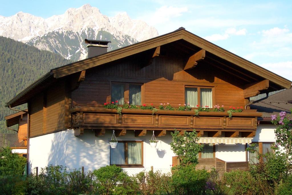 una casa de madera con un balcón con flores. en Appartement Popelka, en Saalfelden am Steinernen Meer