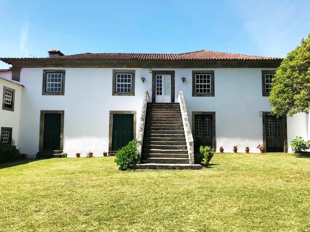 a white house with stairs in the yard at Casa do Retiro in Ponte de Lima