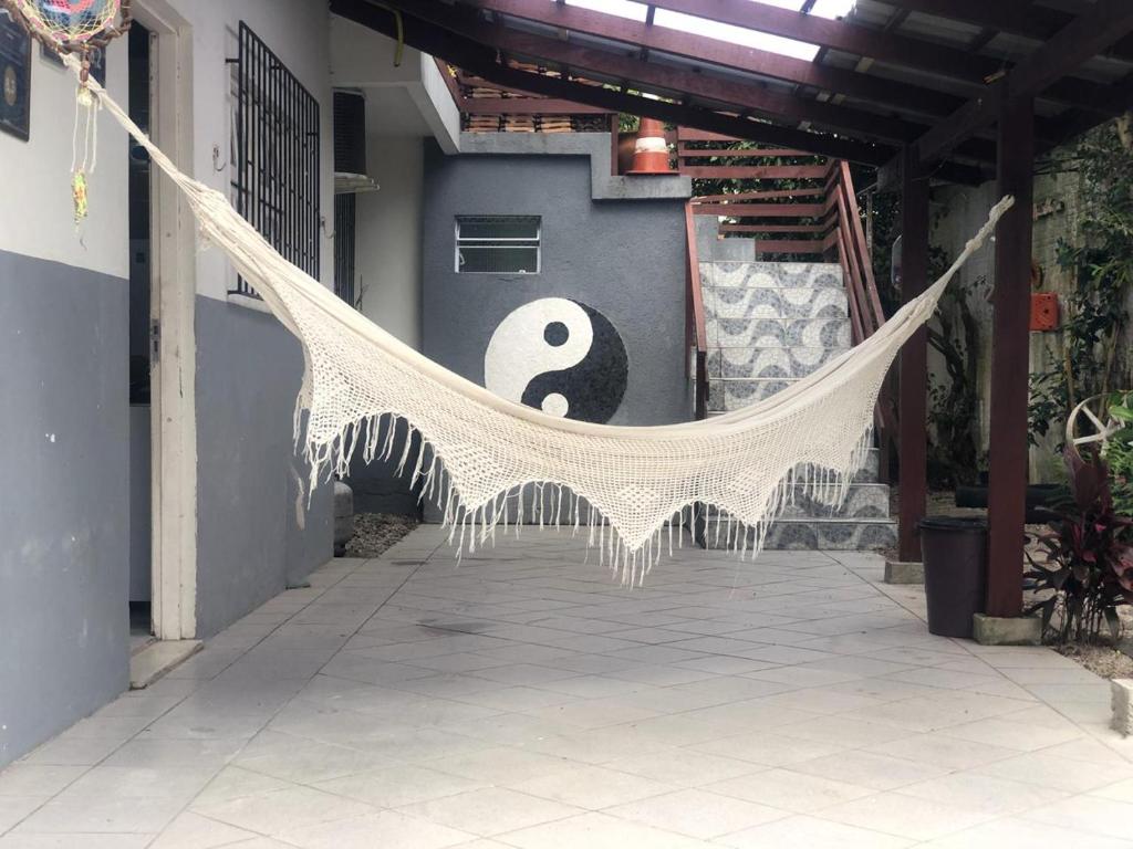 a hammock hanging from a building with a symbol at Residencial Christal Das Flores in Florianópolis