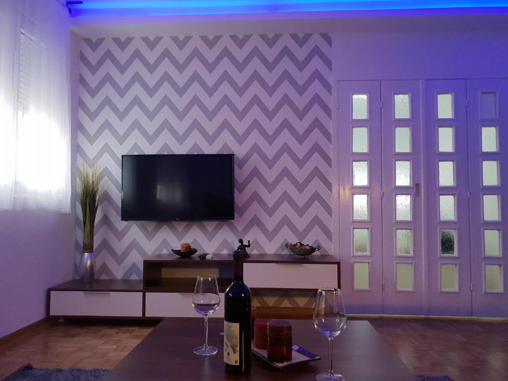 - un salon avec deux verres à vin et une télévision dans l'établissement Apartment Nikola Tesla, à Belgrade