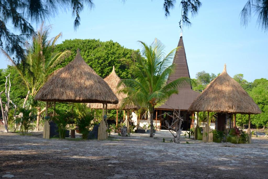 een groep hutten met bomen en palmbomen bij Ecoresort Sumba Dream in Rindi