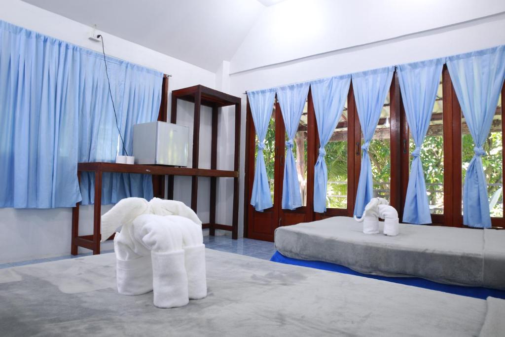 two elephants in a room with a bed at Paradise Bungalows in Haad Rin