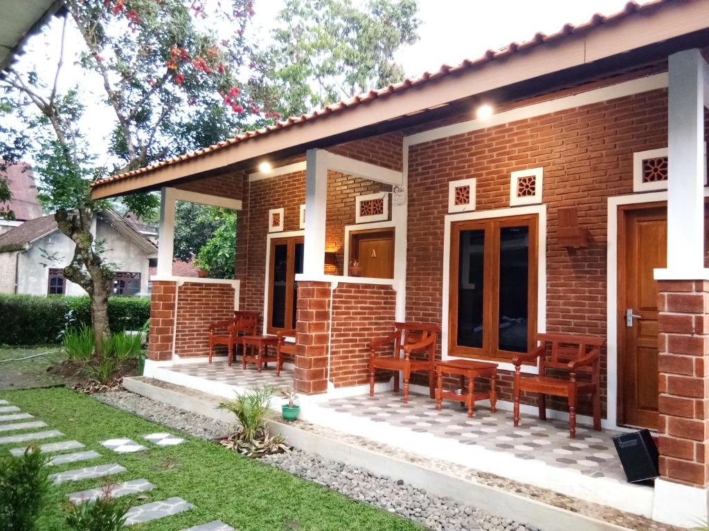 a brick house with benches on a patio at Genthong Homestay in Borobudur