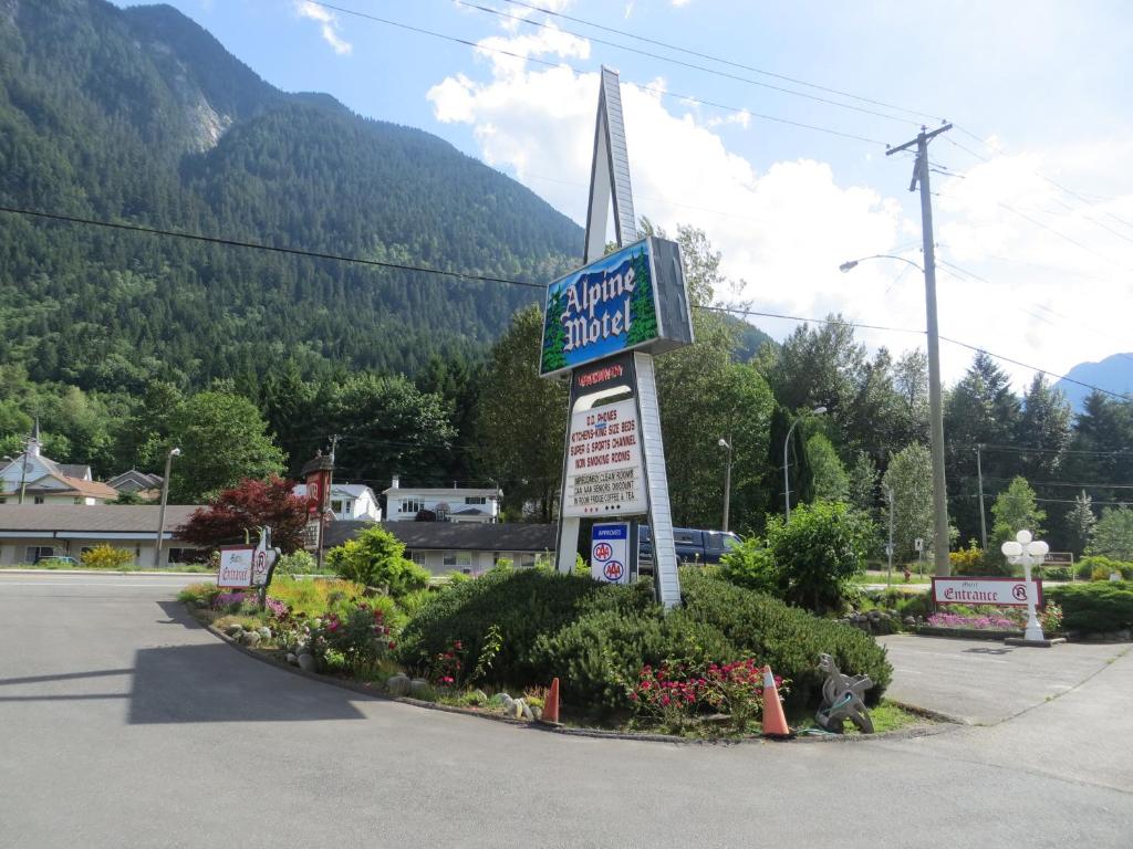 Alpine Motel في هوب: علامة لموتيل مع جبل في الخلفية