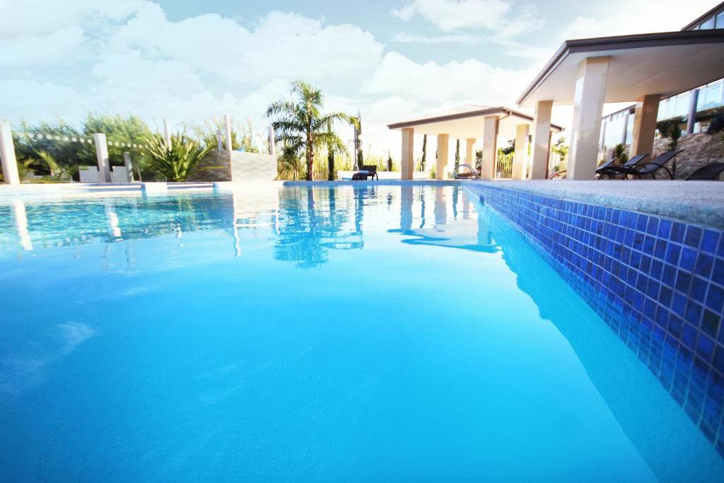 una piscina de agua azul frente a una casa en Swan River Hotel, en Perth