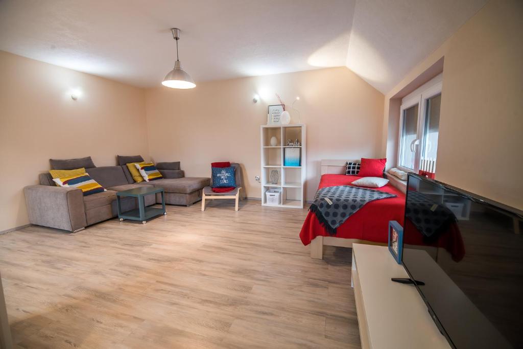 a living room with a bed and a couch at Apartment Stil near Terme Paradiso in Dobova