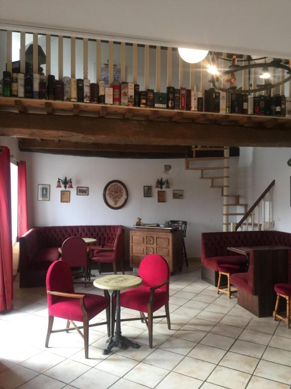 un restaurante con sillas rojas y una mesa en una habitación en La Forge, en Saint-Maurice-en-Cotentin