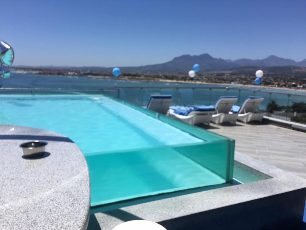 a swimming pool on the roof of a building at GORDON's SHORE LUXURY APARTMENTS - Solar Powered in Gordonʼs Bay