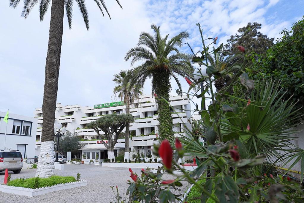 a white building with palm trees in front of it at RAIS in Alger