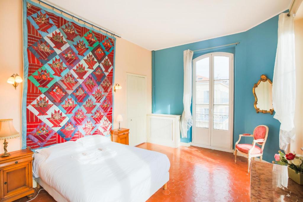- une chambre avec un lit blanc et un mur coloré dans l'établissement NICE ETOILE AP1007 by Riviera Holiday Homes, à Nice