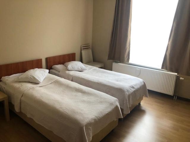 - 2 lits dans une chambre d'hôtel avec fenêtre dans l'établissement Prestige Flats Coteaux, à Bruxelles