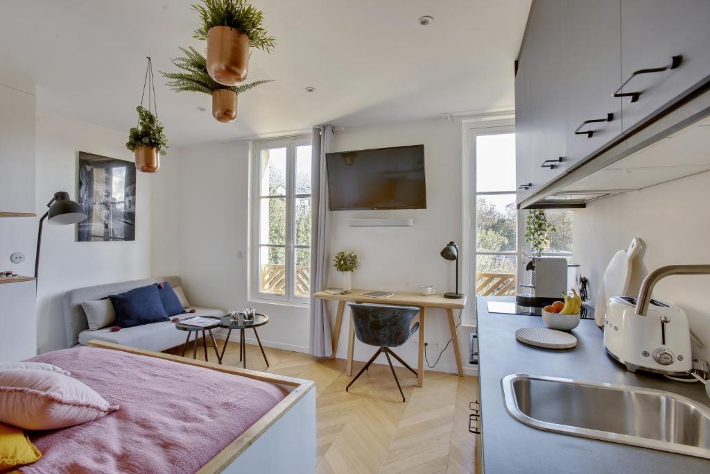 a kitchen and a living room with a sink at L’Alcôve Royale in Versailles