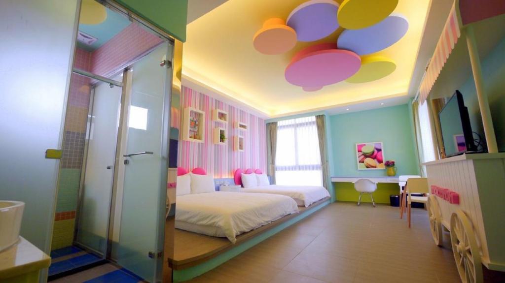 a bedroom with a bed and a ceiling with colorful circles at Bookline B&B in Hualien City