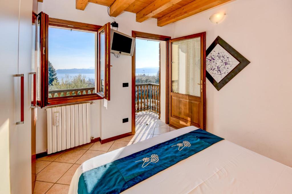 a bedroom with a bed and a balcony at Appartamento Lago Blu in Gardone Riviera