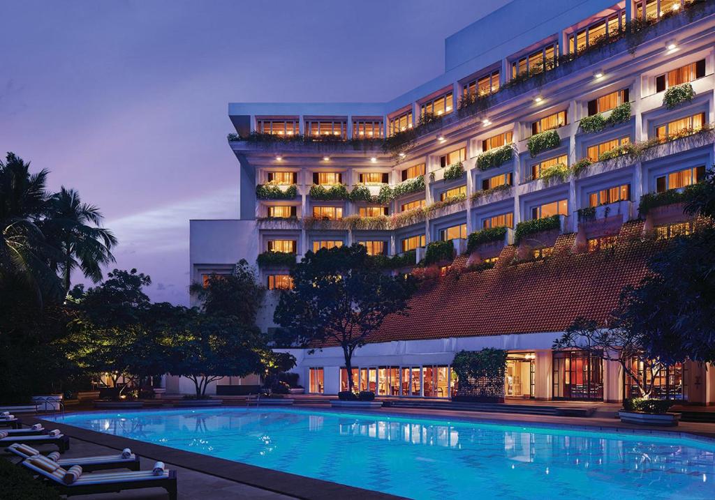 un hôtel avec une piscine en face d'un bâtiment dans l'établissement Taj Bengal, à Kolkata