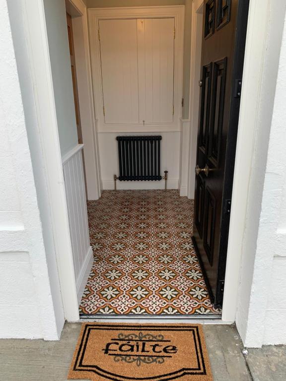 an entrance to a hallway with a rug in front of a door at Biddy Ban’s in Carnmalin