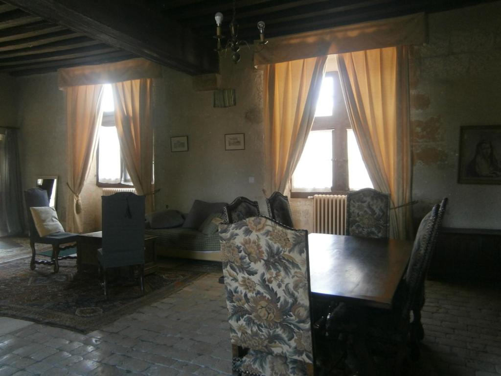 a living room with a couch and chairs and windows at Chateau de Chémery in Chémery
