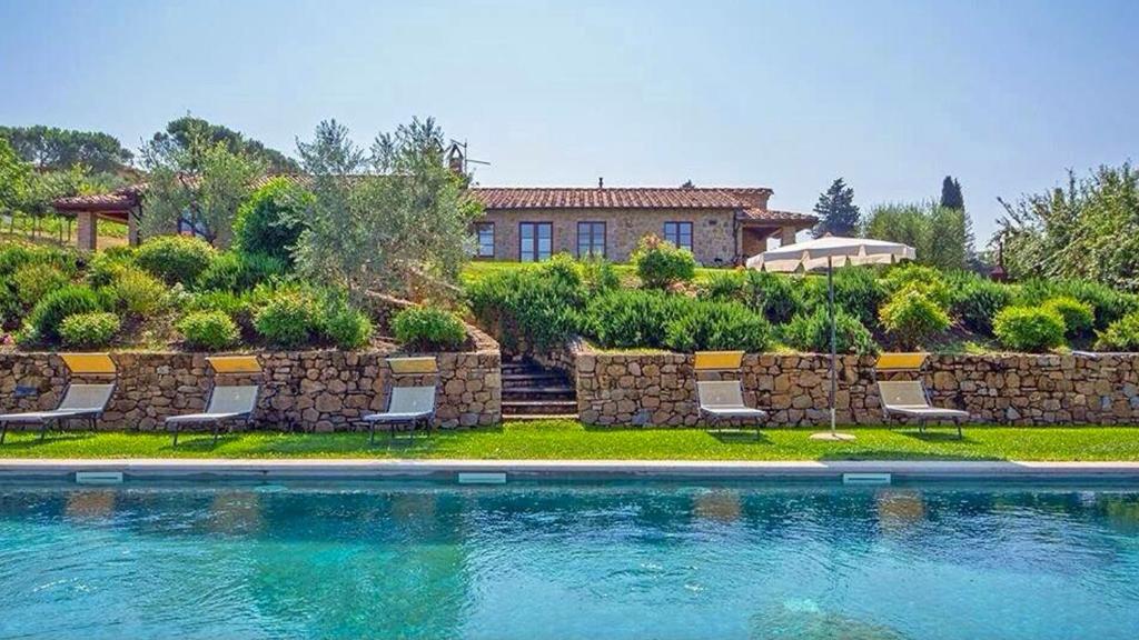 a house with a swimming pool in front of a house at Podere Lamino in Monticchiello