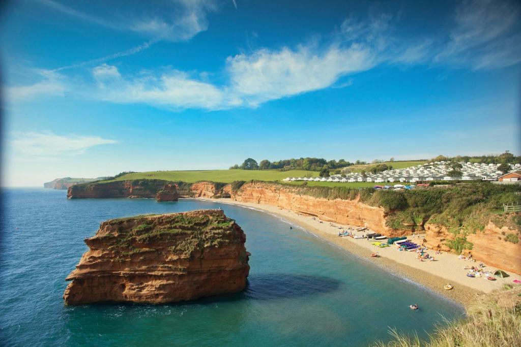 a beach with a large rock in the water at Ladram Bay Holiday Park in Otterton