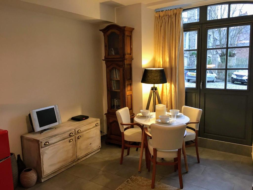 une salle à manger avec une table, des chaises et une télévision dans l'établissement Gate House Lodge, à Dinan