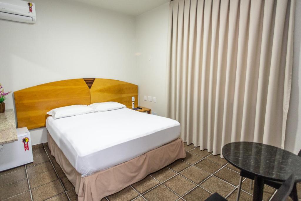 a hotel room with a bed and a table at Panorama Convention Hotel in Coronel Fabriciano