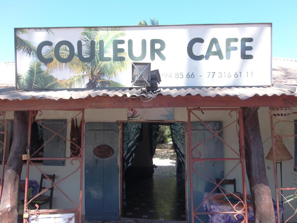 un panneau indiquant le café sud au-dessus d'un bâtiment dans l'établissement Couleur Café, à Kafountine