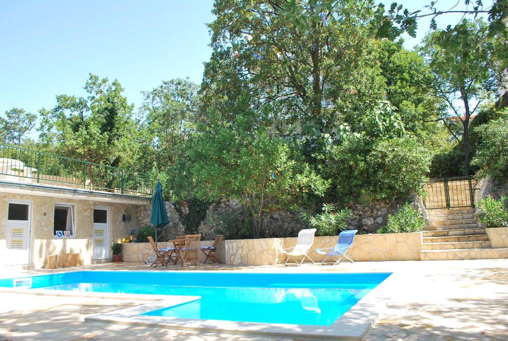 a swimming pool with chairs and a house at Holiday Home Villa "Paradise Farm" in Crikvenica