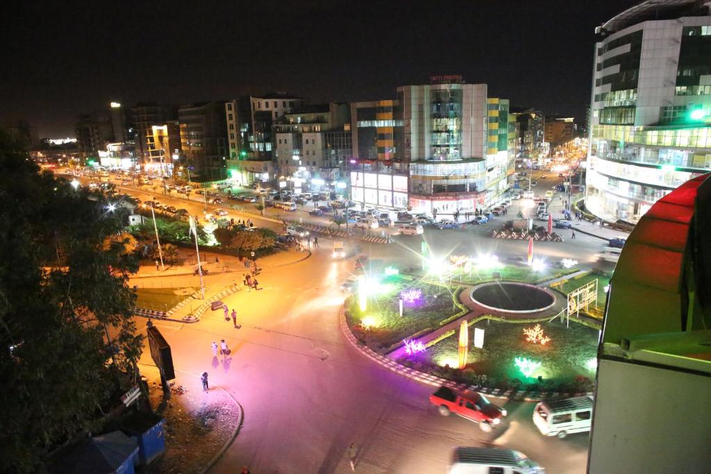 una strada di città di notte con edifici e luci di Trinity Hotel ad Addis Abeba