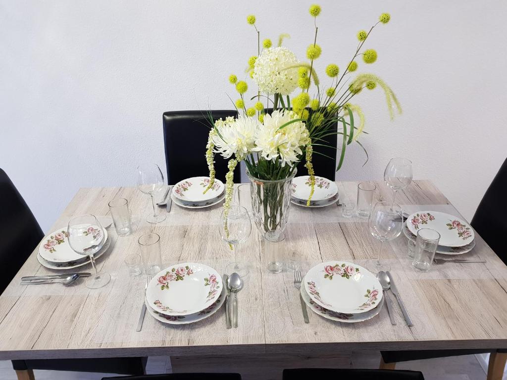 een tafel met borden en een vaas met bloemen erop bij Großes Ferienhaus in Hannover Messe Nähe in Sarstedt