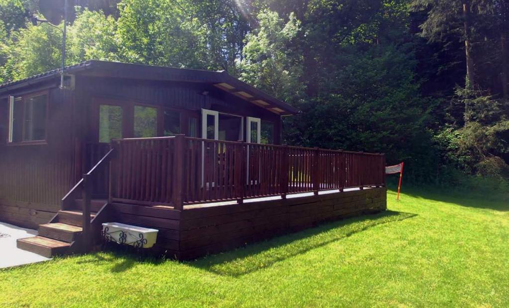 a small cabin in a field of grass at 28 Riverside, Caer Beris Holiday Park in Builth Wells