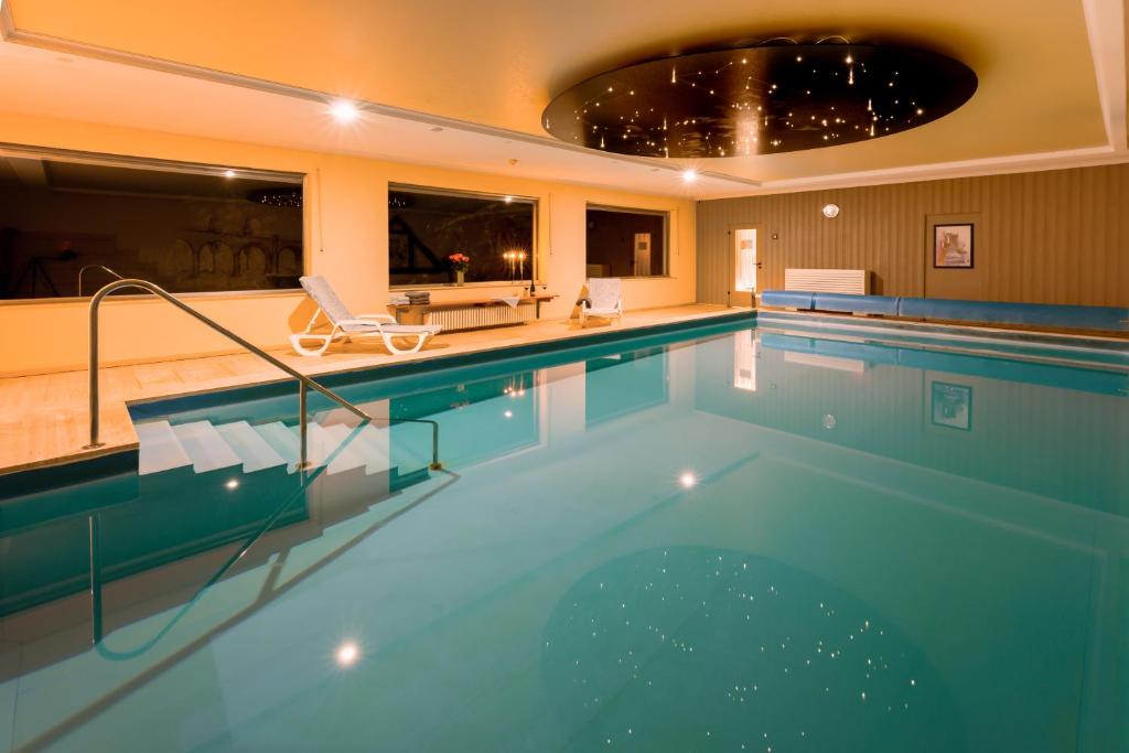 a large swimming pool in a hotel room with a pool at Hotel Luisen Mühle in Mengeringhausen