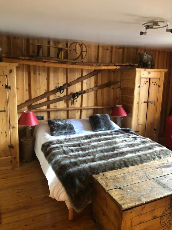 a bedroom with a large bed with wooden walls at Hôtel Restaurant de la Chaussée in Briançon