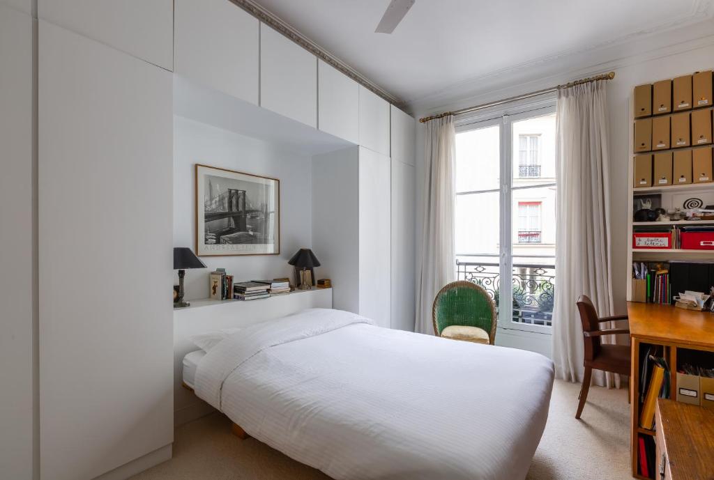 a white bedroom with a bed and a desk at Veeve - Artistic in Pigalle in Paris